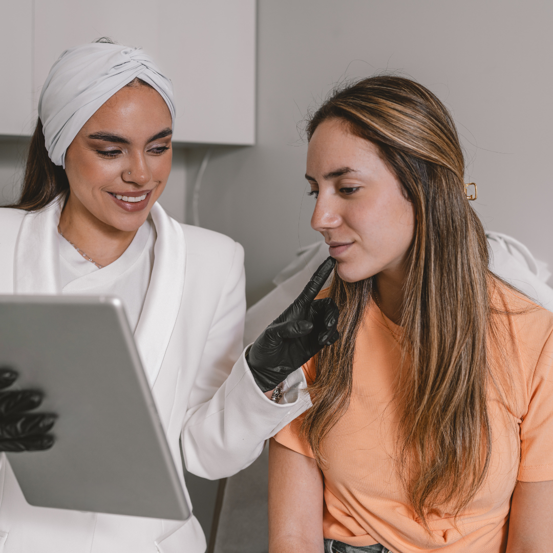 Esthetician explaining Botox results to a patient using a digital tablet.