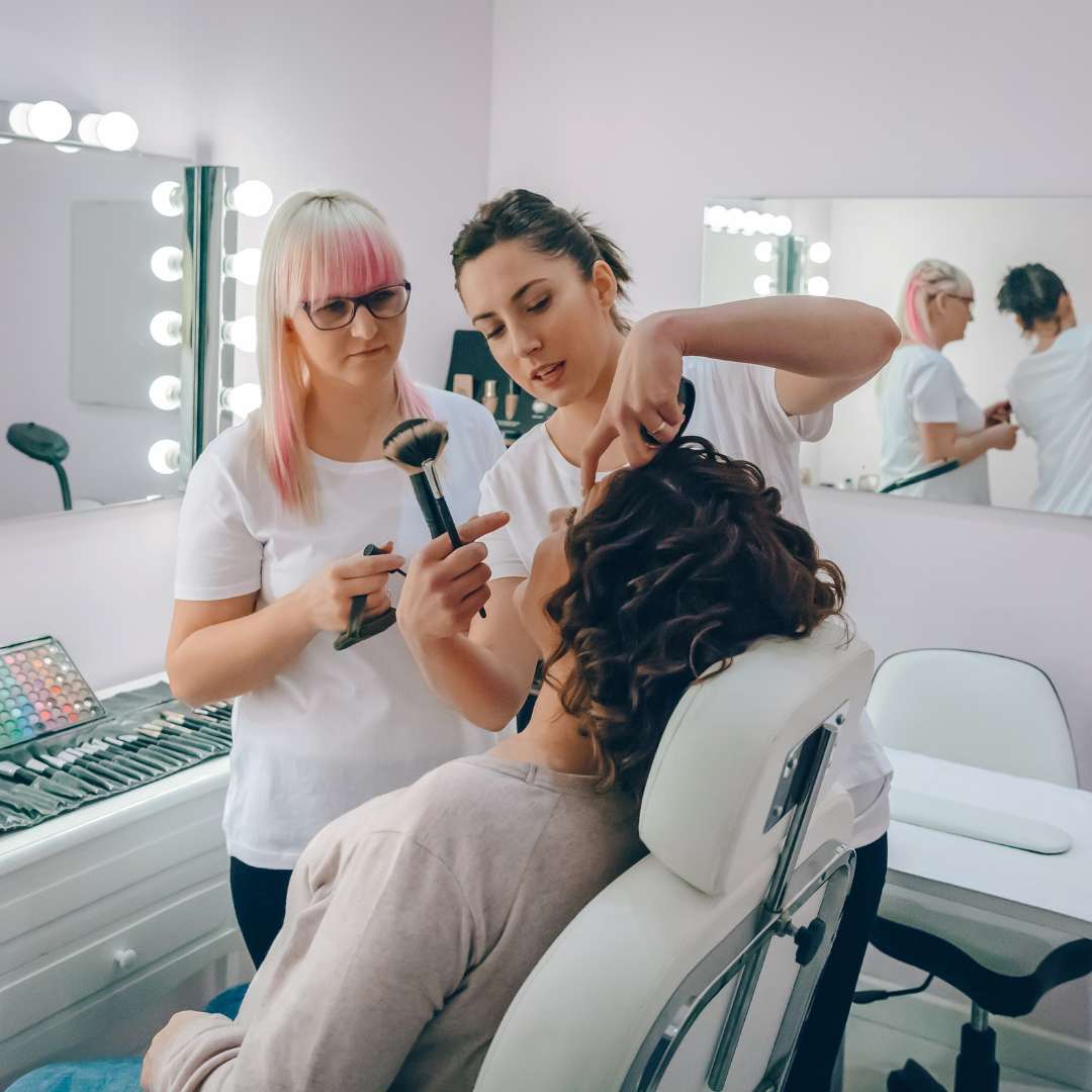 Makeup artist teaching makeup techniques in a beauty center, offering advanced esthetics training.