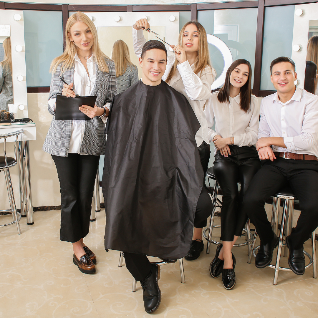 Beauty school students learning under the guidance of their teacher while practicing on a client during a massage therapy training session.